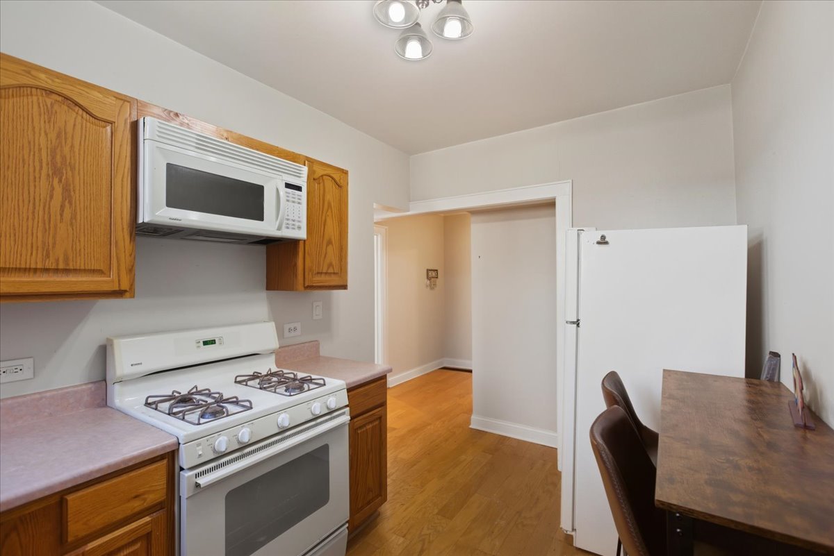 4055 North Spaulding Avenue, Unit 1 Chicago, IL 60618 - Photo 5 of 13 a kitchen with stainless steel appliances granite countertop a stove a sink and a refrigerator
