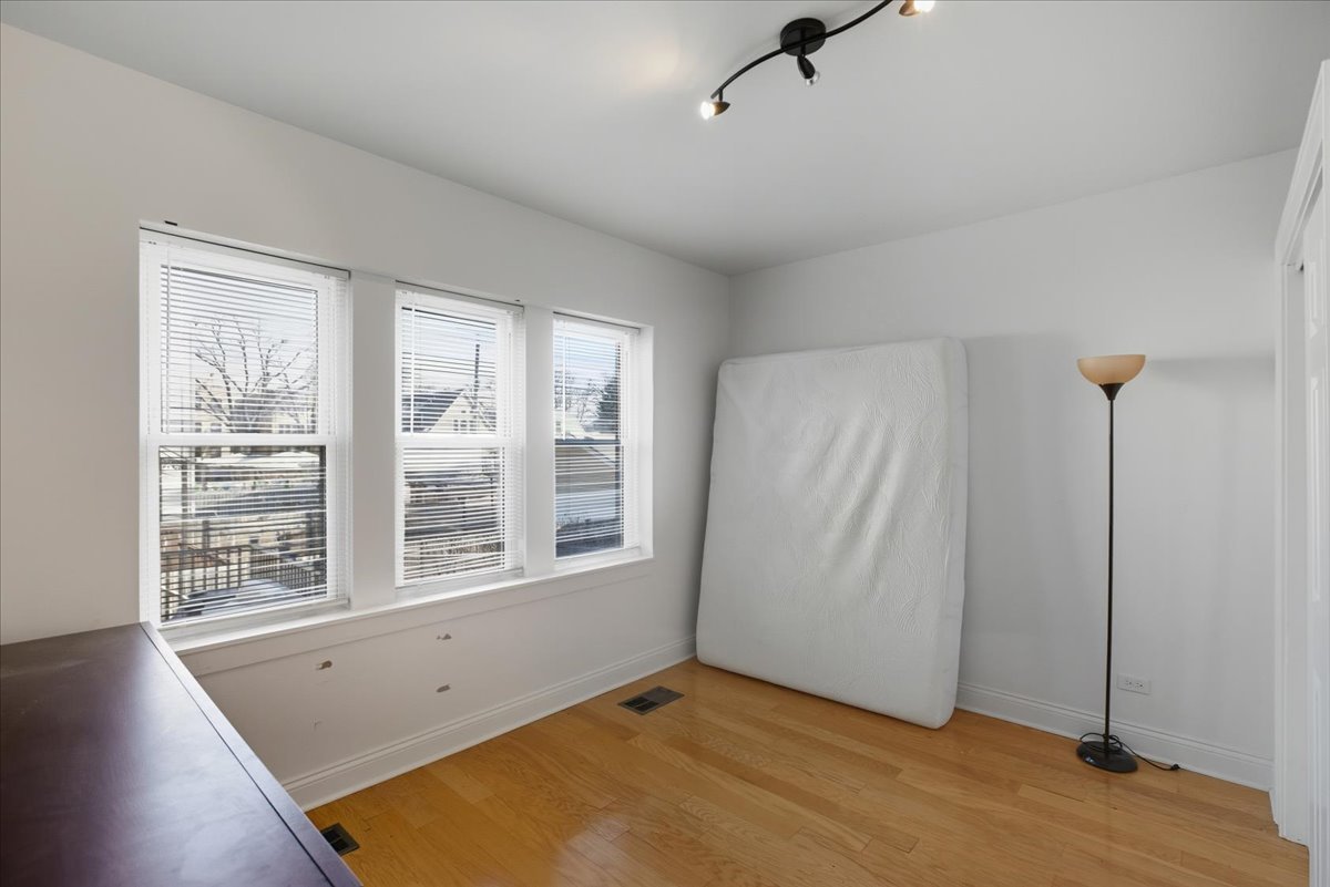 4055 North Spaulding Avenue, Unit 1 Chicago, IL 60618 - Photo 6 of 13 an empty room with windows