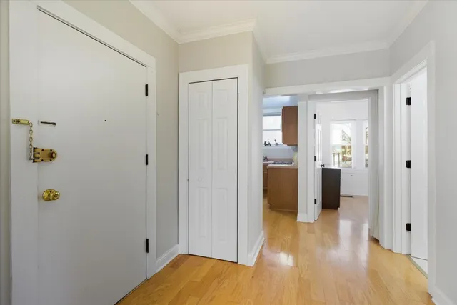 a view of a hallway with wooden floor and closet area