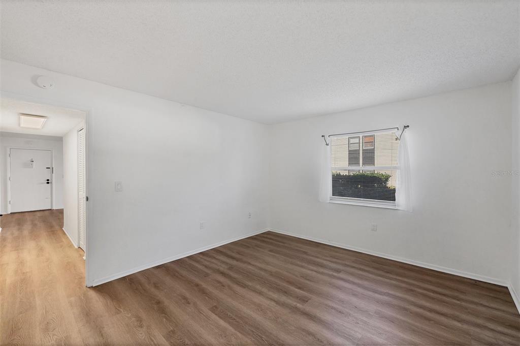 3231 South Beneva Road, Unit 103 Sarasota, FL 34232 - Photo 12 of 31 an empty room with wooden floor and windows