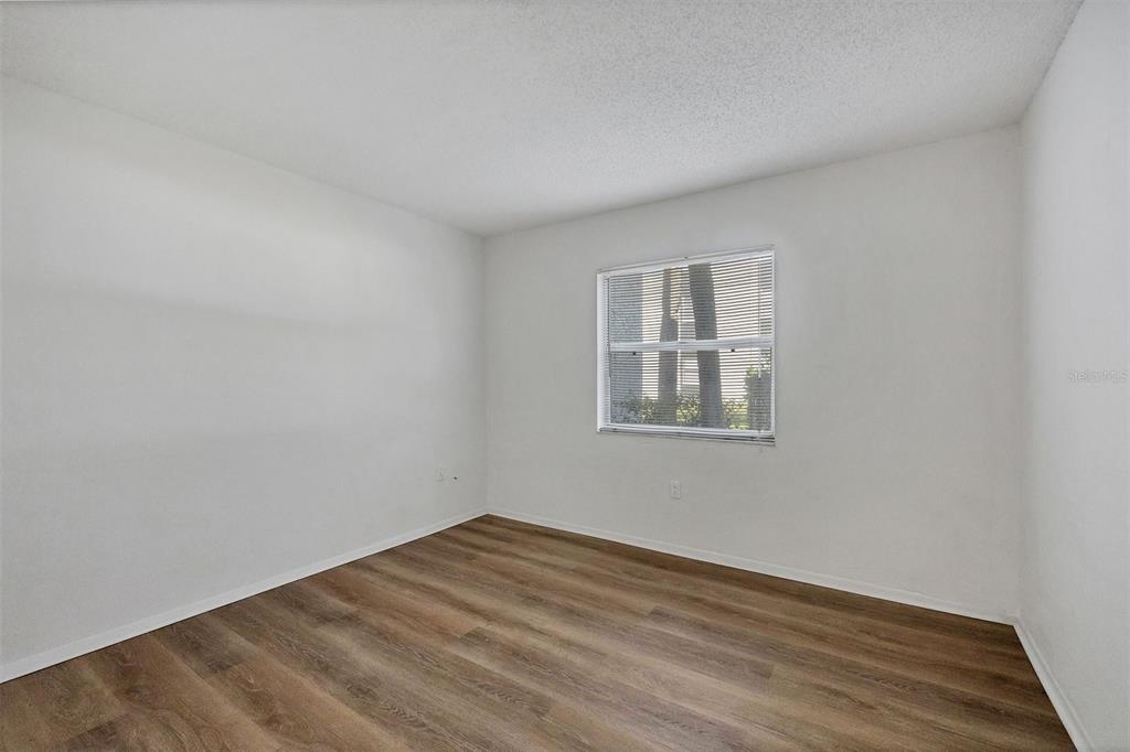 3231 South Beneva Road, Unit 103 Sarasota, FL 34232 - Photo 16 of 31 a view of empty room with wooden floor and fan