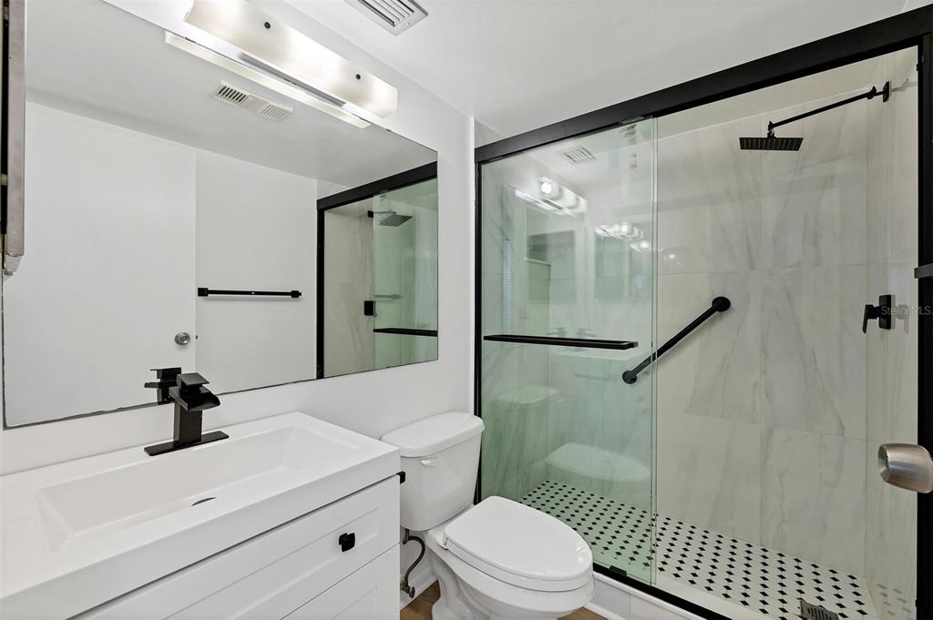 3231 South Beneva Road, Unit 103 Sarasota, FL 34232 - Photo 17 of 31 a bathroom with a sink a toilet a mirror and shower