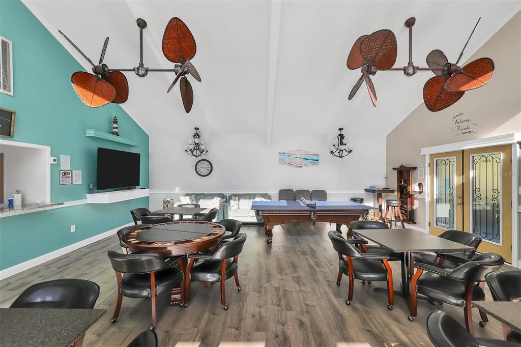 3231 South Beneva Road, Unit 103 Sarasota, FL 34232 - Photo 23 of 31 a dining room with wooden floor a chandelier a wooden table and chairs