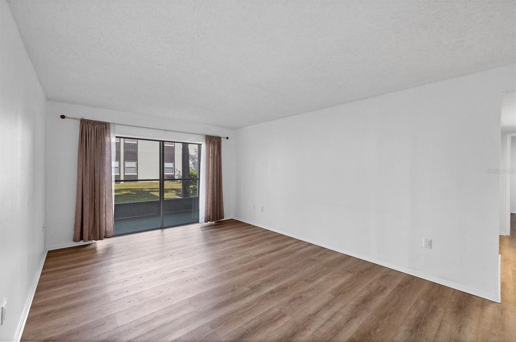 3231 South Beneva Road, Unit 103 Sarasota, FL 34232 - Photo 6 of 31 a view of an empty room with wooden floor