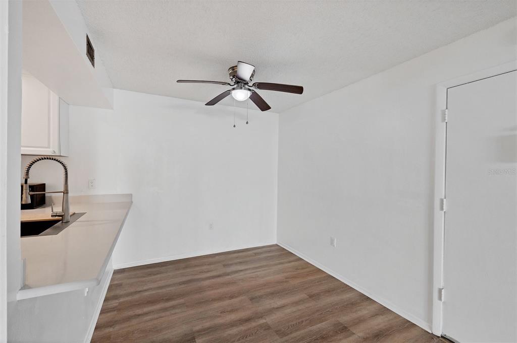 3231 South Beneva Road, Unit 103 Sarasota, FL 34232 - Photo 7 of 31 a view of a room with wooden floor and white walls