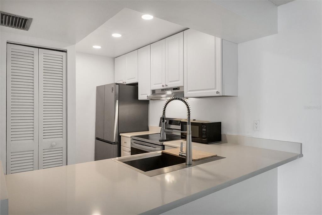 3231 South Beneva Road, Unit 103 Sarasota, FL 34232 - Photo 8 of 31 a kitchen with stainless steel appliances granite countertop a sink a stove and a refrigerator