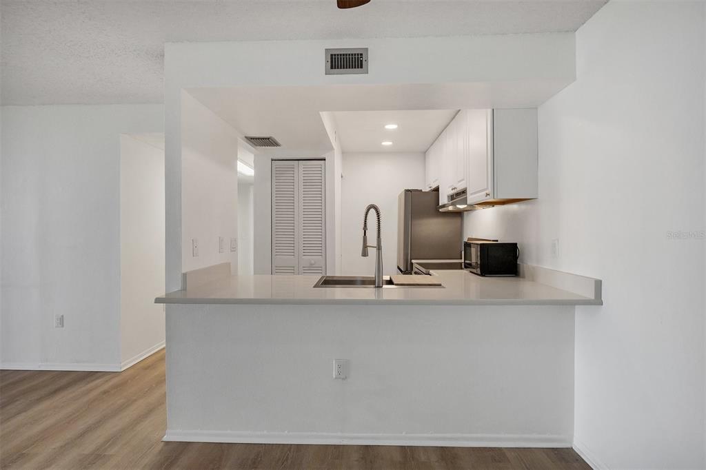 3231 South Beneva Road, Unit 103 Sarasota, FL 34232 - Photo 9 of 31 a view of a kitchen with kitchen island a sink stainless steel appliances and cabinets