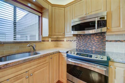 a kitchen with stainless steel appliances granite countertop a stove and a microwave