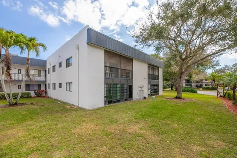 a view of a house with a big yard and large tree