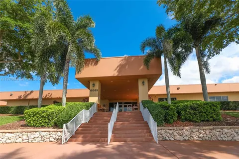 a view of a patio with table and chairs under an umbrella
