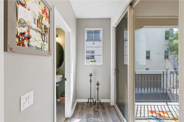 a view of a hallway with wooden floor and a dining room