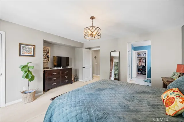 a bedroom with a bed and a tv on dresser