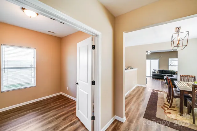 a view of a livingroom with wooden floor and furniture