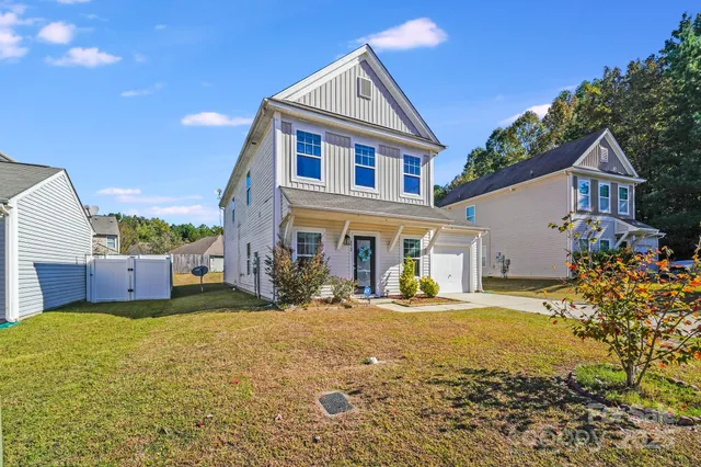 a front view of a house with a yard and outdoor seating