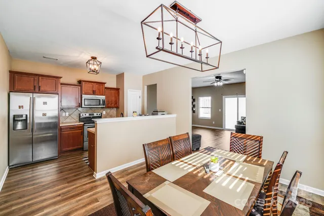 a living room with stainless steel appliances kitchen island a table and chairs