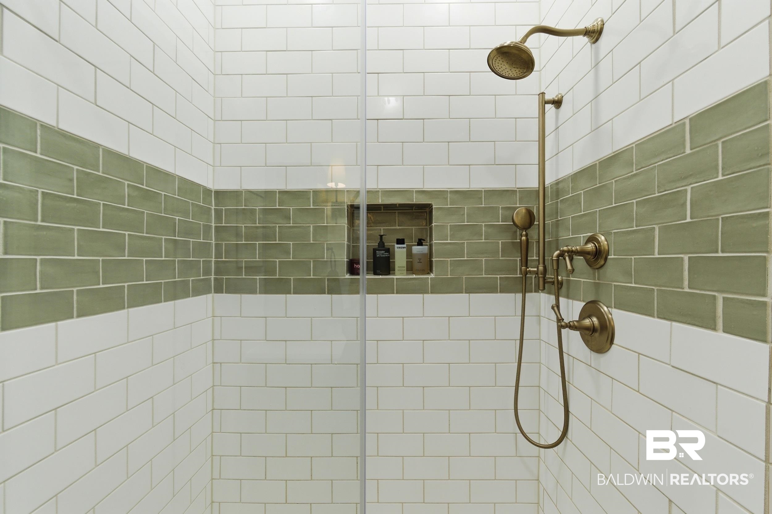 350 Charles Street Mobile, AL 36604 - Photo 21 of 52 Subway-tiled shower enclosure with a horizontal band of sage green tile