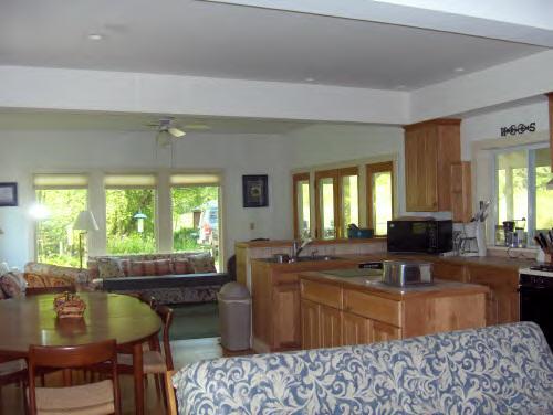 149 Tyringham Road Monterey, MA 01245 - Photo 2 of 6 a kitchen with a stove a sink a dining table and chair