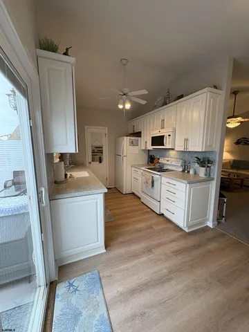 a kitchen with stainless steel appliances granite countertop a stove top oven a sink and a refrigerator