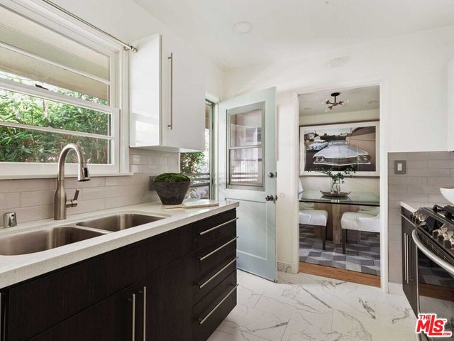 a kitchen with stainless steel appliances a sink stove and cabinets