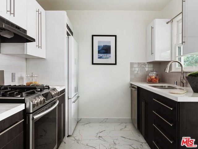 a kitchen with stainless steel appliances granite countertop a stove a refrigerator and a granite counter tops