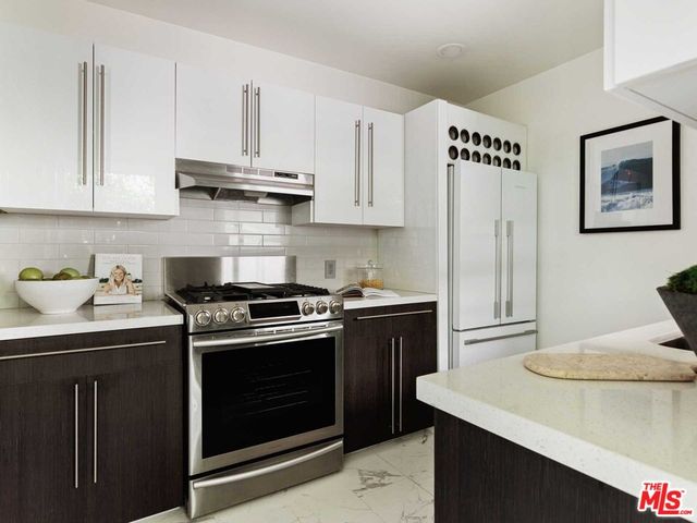 a kitchen with appliances cabinets and a potted plant