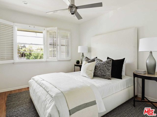 a bedroom with bed and a large window