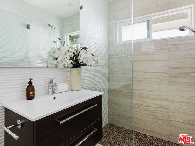 a bathroom with a sink a mirror and shower
