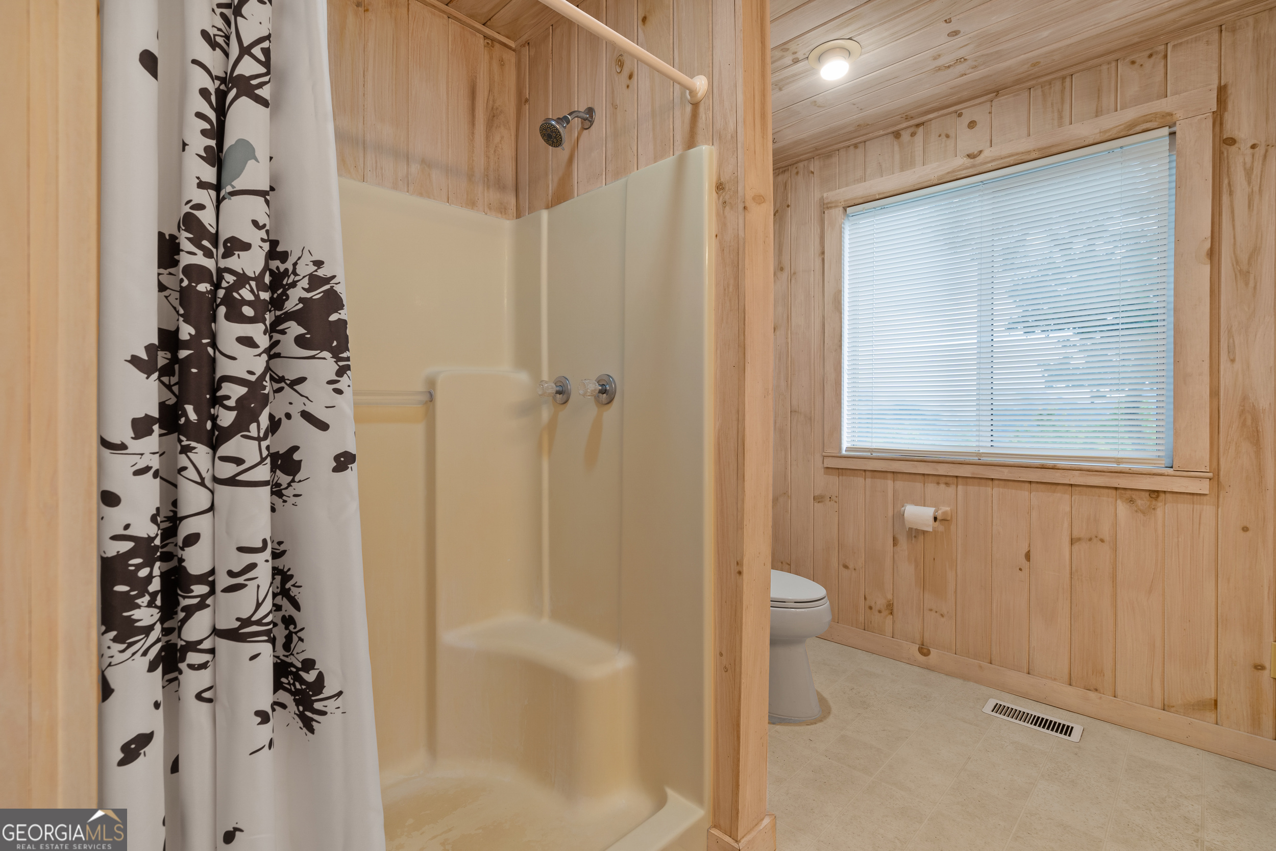 1387 Valley Street Clayton, GA 30525 - Photo 32 of 59 a bathroom with a shower curtain and a toilet