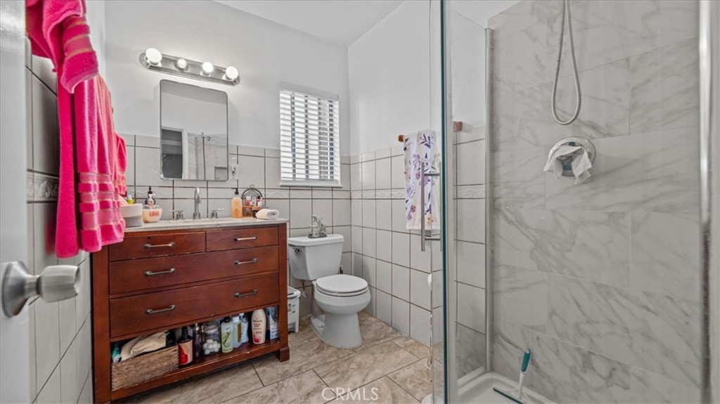 215 West Valencia Street Rialto, CA 92376 - Photo 11 of 17 a bathroom with a sink a toilet and shower curtain