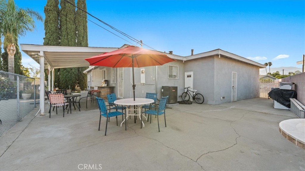 215 West Valencia Street Rialto, CA 92376 - Photo 14 of 17 a patio with a table and chairs under an umbrella