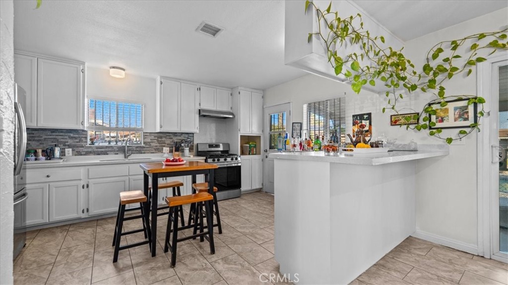 215 West Valencia Street Rialto, CA 92376 - Photo 2 of 17 a kitchen with stainless steel appliances granite countertop a refrigerator and a stove top oven