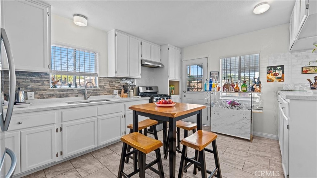 215 West Valencia Street Rialto, CA 92376 - Photo 3 of 17 a room with a table chairs and a refrigerator