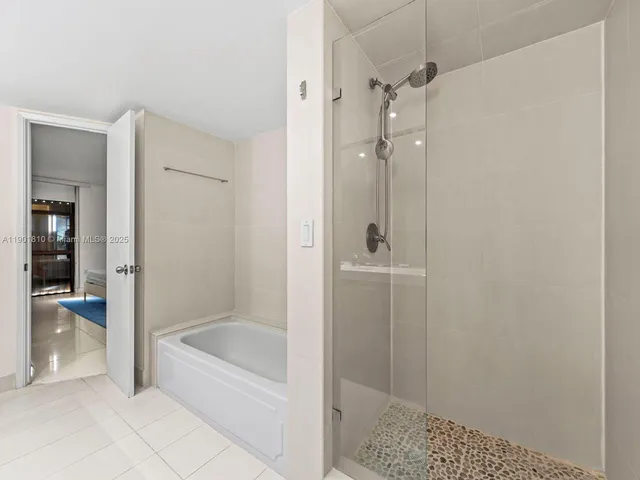 a view of a hallway with wooden floor and a bathroom