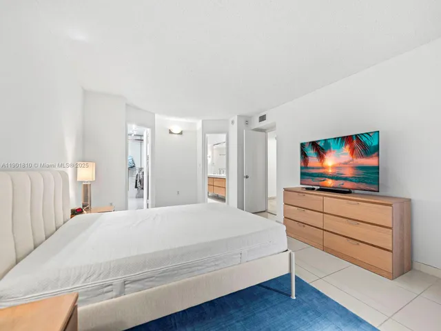 a spacious bedroom with a bed and cabinet