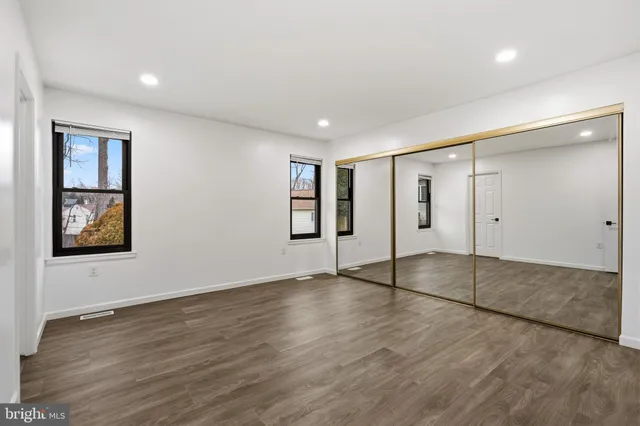 an empty room with wooden floor and window