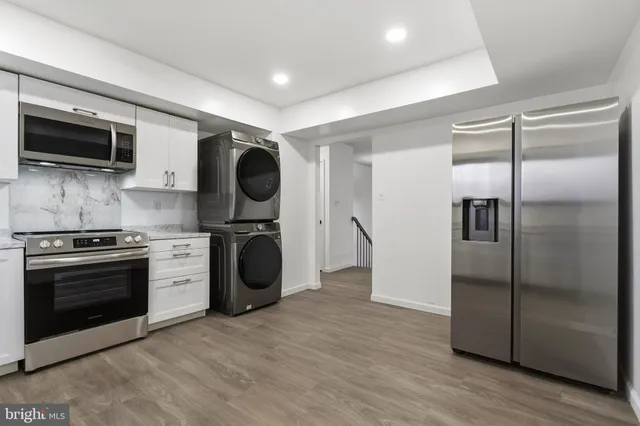a kitchen with stainless steel appliances granite countertop a refrigerator and a stove top oven