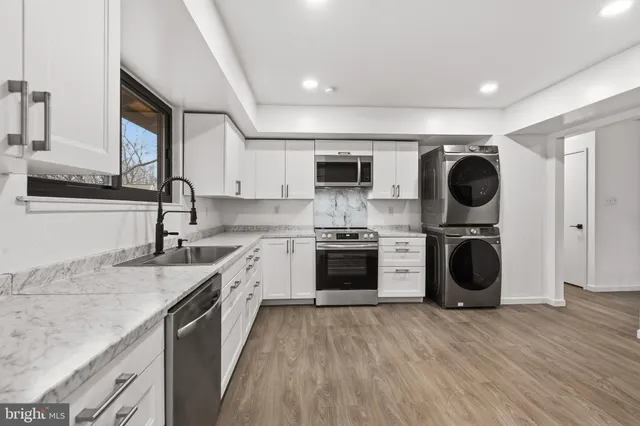 a kitchen with a sink dishwasher a stove and a microwave oven with cabinets