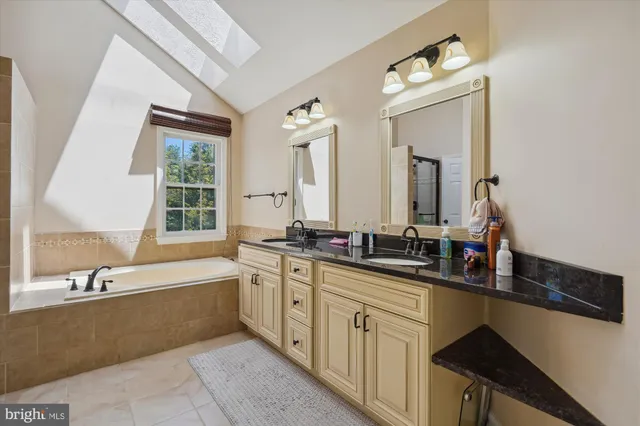 a bathroom with a tub sink and mirror