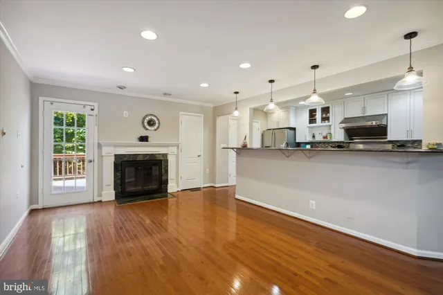 a view of kitchen with microwave a stove and wooden floor