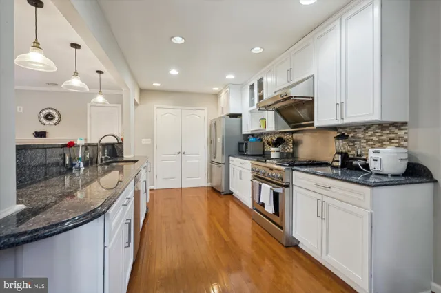 a kitchen with stainless steel appliances granite countertop a sink stove and refrigerator