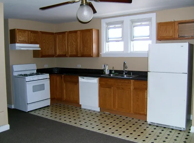 a kitchen with granite countertop a sink cabinets and stainless steel appliances