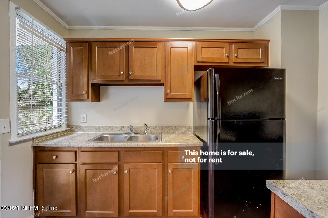 4611 Pinewood Road Jacksonville, FL 32210 - Photo 8 of 21 a kitchen with a sink a stove and a refrigerator