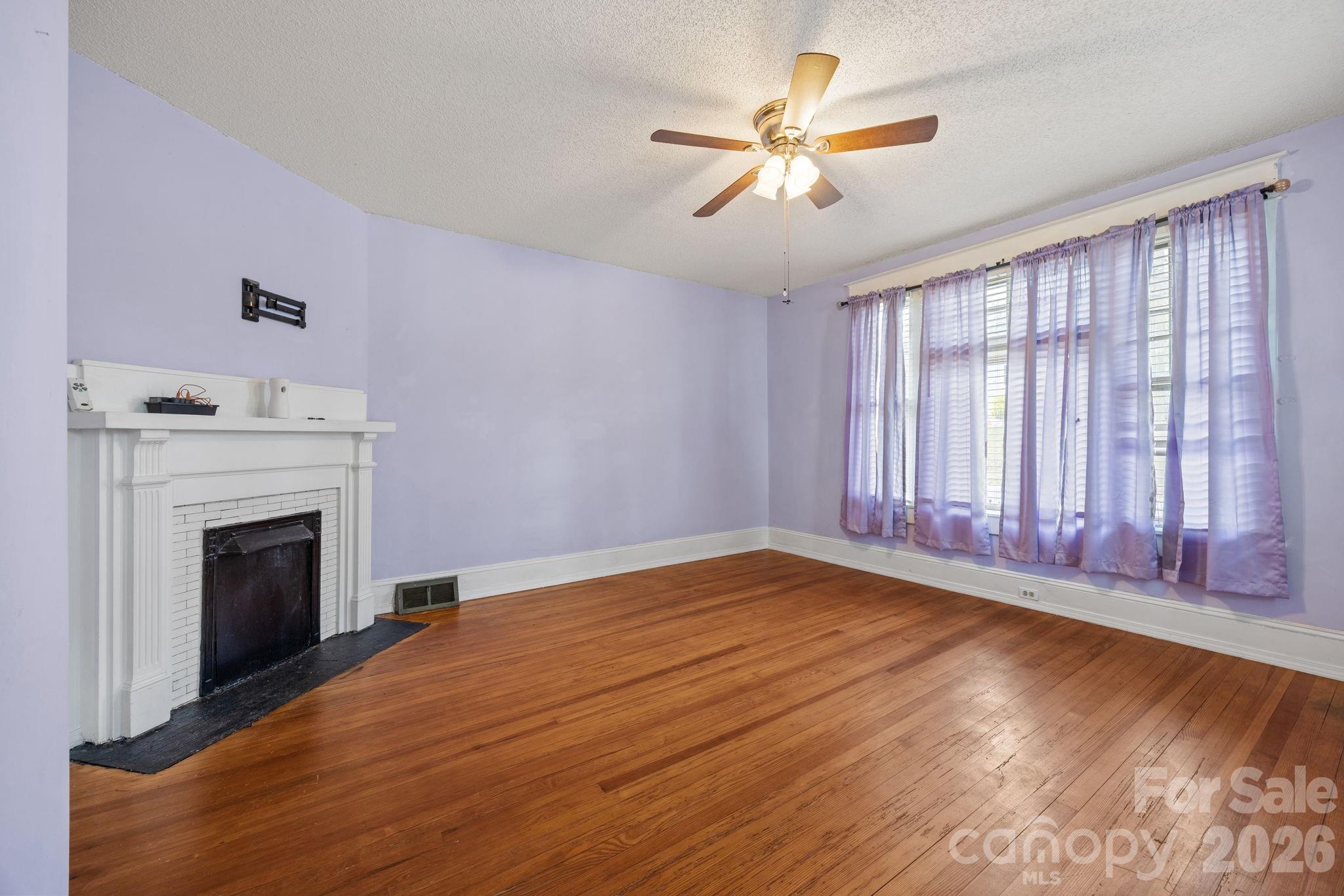 628 West Council Street Salisbury, NC 28144 - Photo 26 of 43 a view of empty room with wooden floor and fireplace
