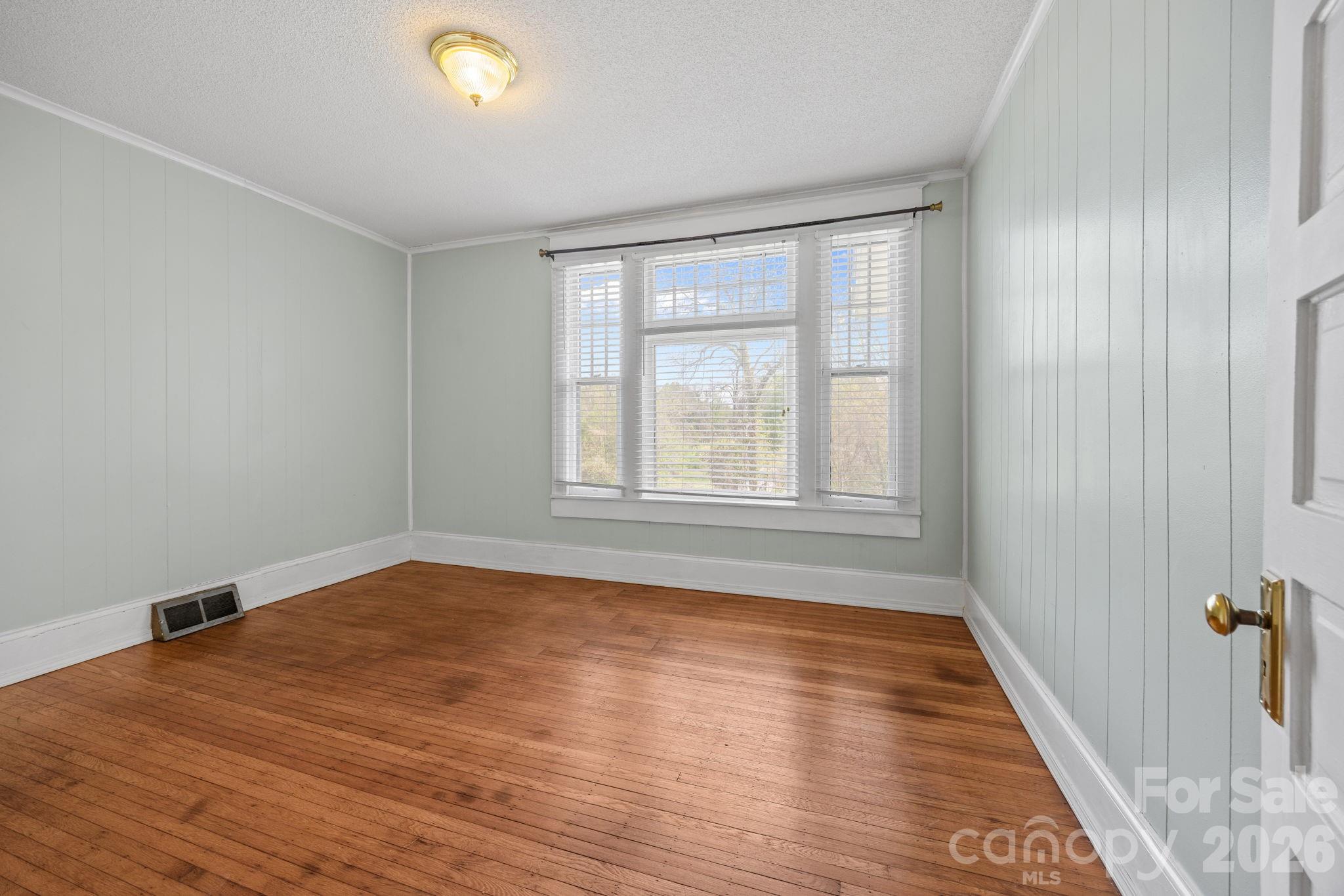 628 West Council Street Salisbury, NC 28144 - Photo 30 of 43 a view of an empty room with wooden floor and a window