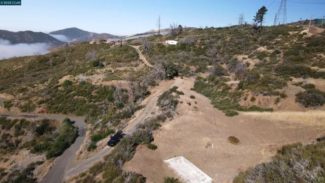 a view of a dry yard with mountains in the background