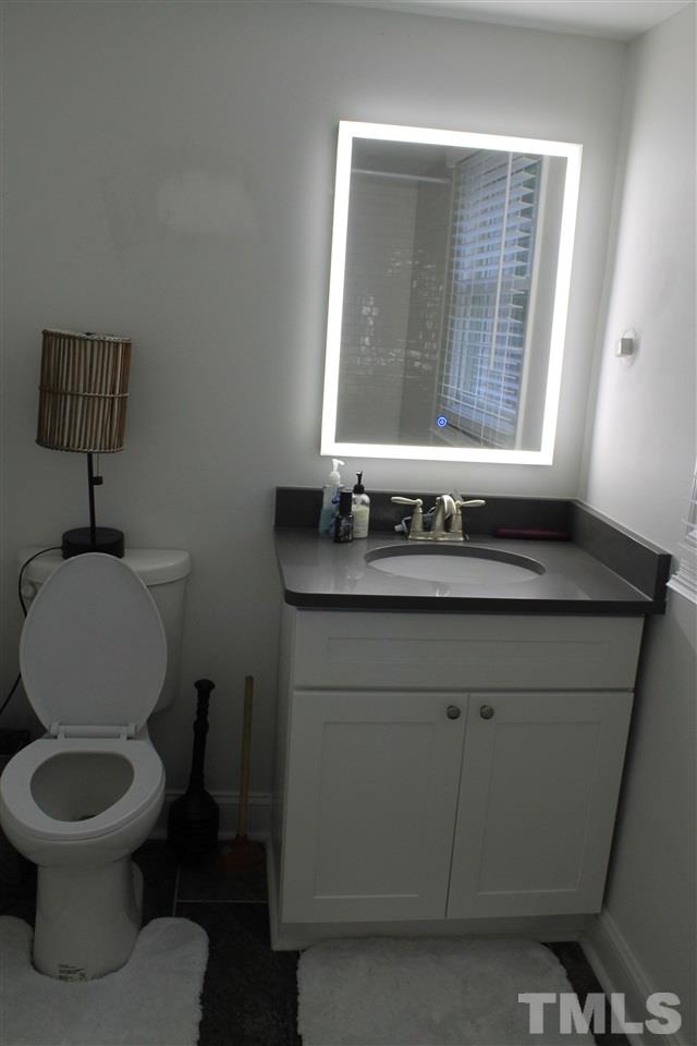 4401 Pike Road Raleigh, NC 27613 - Photo 7 of 14 a bathroom with a toilet sink and mirror