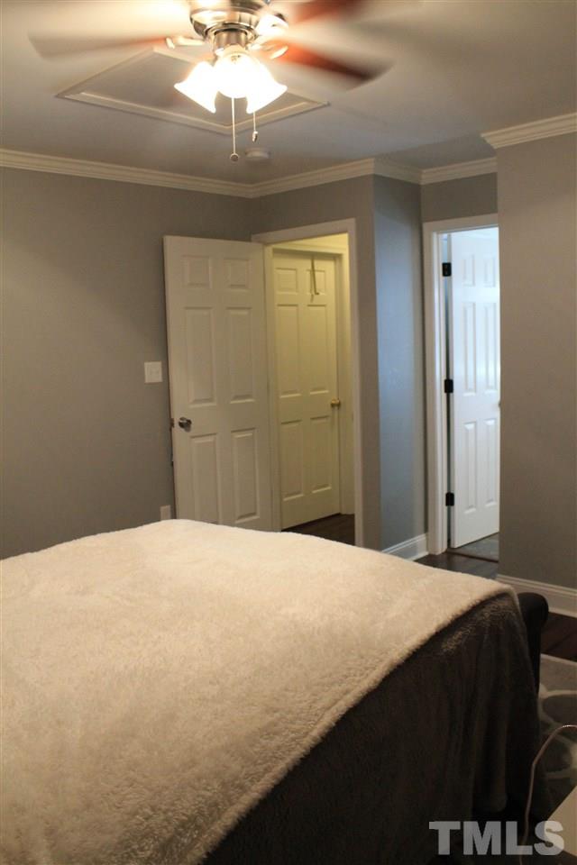 4401 Pike Road Raleigh, NC 27613 - Photo 9 of 14 a bedroom with a bed and a chandelier