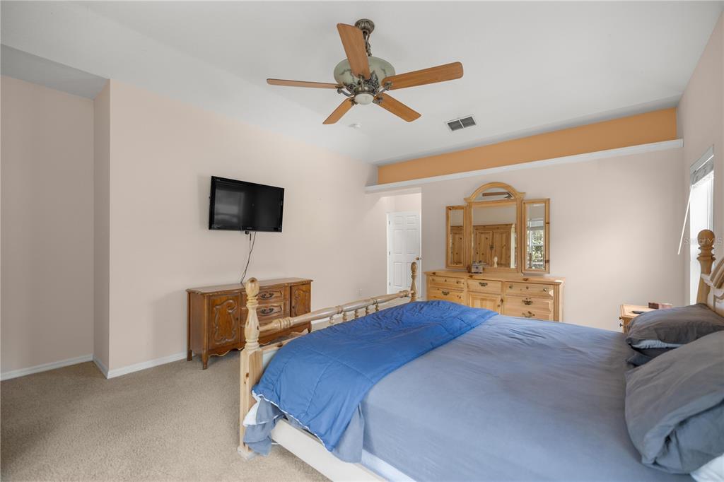19040 Northwest 88th Avenue Road Reddick, FL 32686 - Photo 21 of 68 a bedroom with a bed a window and a flat screen tv