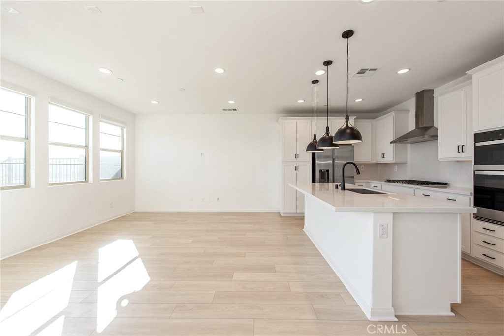 781 Cornelia Way Rancho Mission Viejo, CA 92694 - Photo 11 of 24 a kitchen with stainless steel appliances kitchen island granite countertop a sink a stove and a wooden floors
