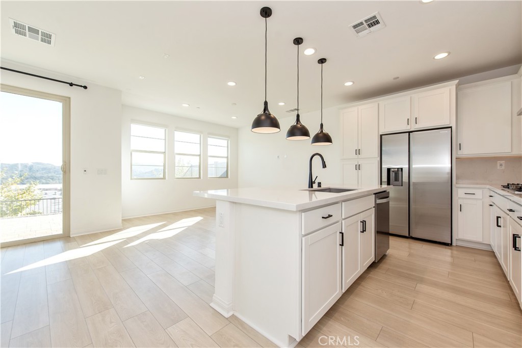 781 Cornelia Way Rancho Mission Viejo, CA 92694 - Photo 6 of 24 a kitchen with stainless steel appliances granite countertop a refrigerator a sink and a wooden floors